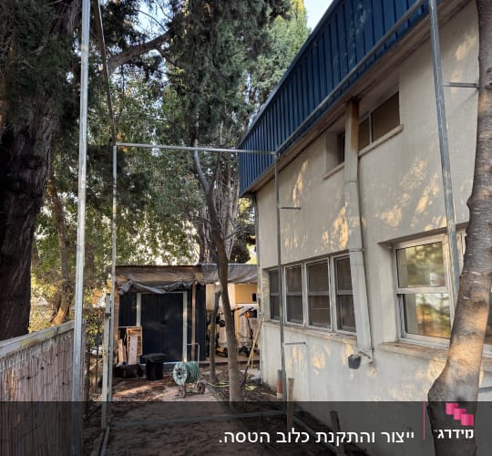 מסגרת מתכת גדולה ליד מבנה עם חלונות